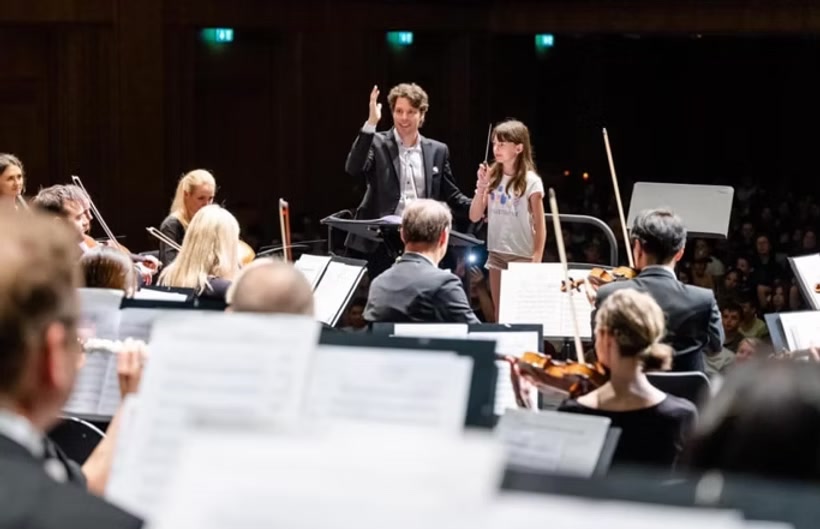 Young conductor in front of the orchestra
