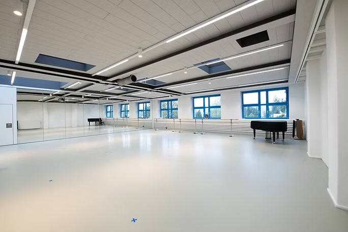 Rehearsal room with grand piano and mirrored wall